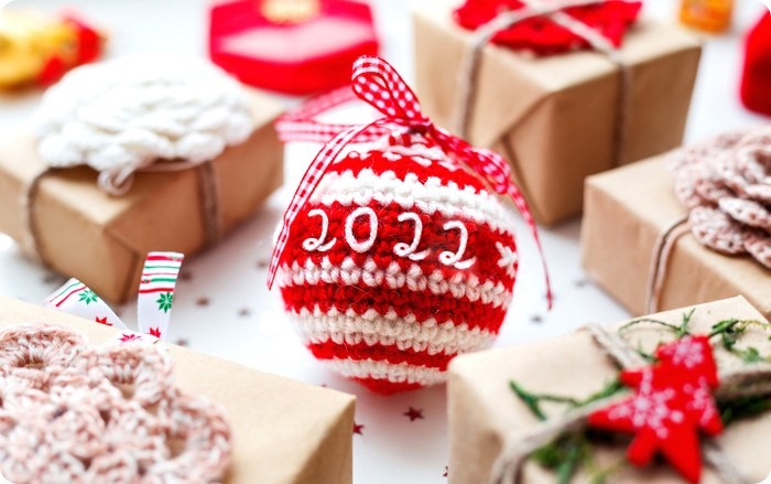 Christmas and New Year 2020 background with presents, decorations and crocheted handmade decorative ball.